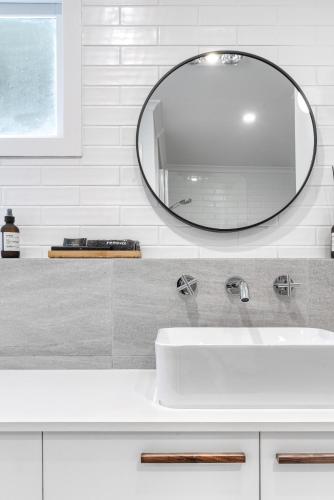 Un baño con un lavabo blanco y un espejo. en Cammeray Waters, en Ashbourne