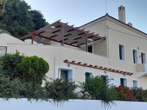 a large white building with a roof at Apoikia house with sea view 6max in Apoíkia