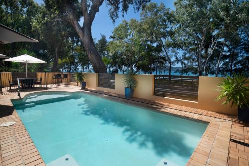 een groot zwembad met een hek en bomen bij Latitude 17 - Suite 3 in South Mission Beach