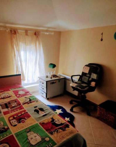 a bedroom with a bed and a chair and a desk at Apoikia house with sea view 6max in Apoíkia