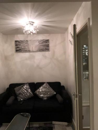 北安普敦的住宿－Northampton Central Oasis，客厅里一张黑色沙发,配有吊灯