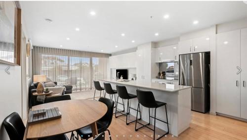 a kitchen and living room with a table and chairs at Ocean Grove Breeze On The Terrace Coastal Apartment in Ocean Grove