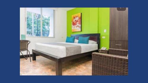 Hotel Sevilla Neiva في نيفا: غرفة نوم بسرير وجدار أخضر