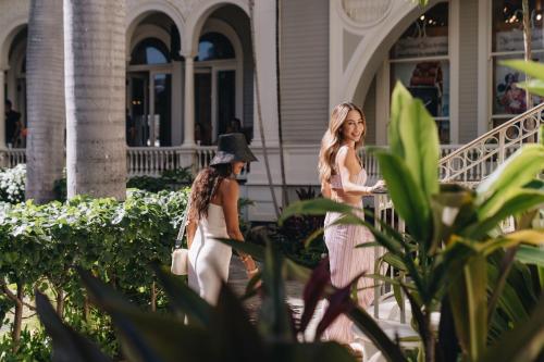 two women walking in front of a building at Moana Surfrider, A Westin Resort & Spa, Waikiki Beach in Honolulu