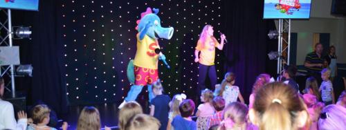 a group of children watching two people on a stage at Hoburne Naish CS129 in New Milton
