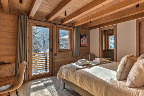 A bed or beds in a room at Chalet Belle des Neiges - Alpes Travel - Sleeps 9