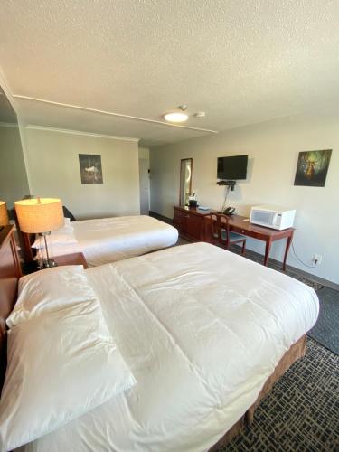 a hotel room with two beds and a desk at Bavarian Inn in Bruce Mines
