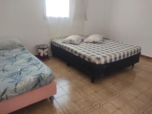 two twin beds in a room with at Pousada em Mongaguà Kali 2 in Mongaguá