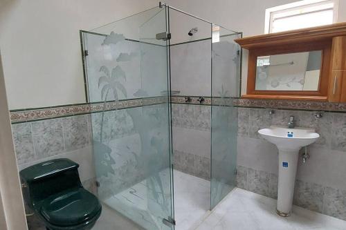 ein Bad mit einer Dusche, einem WC und einem Waschbecken in der Unterkunft Finca en Copacabana con piscina y cancha de futbol in Girardota