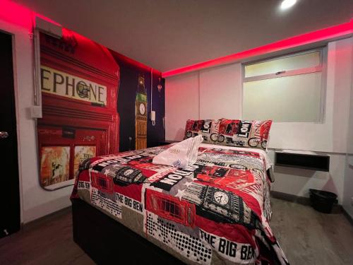 a bedroom with a bed with a comforter and pillows at Dubai motel vip in Bogotá