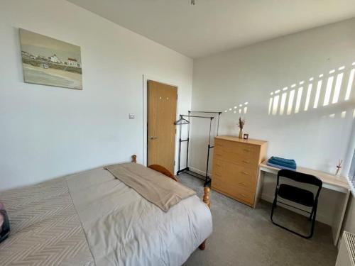 a bedroom with a bed and a dresser and a desk at 2 Bedroom Flat in Town Center Wellingborough in Wellingborough