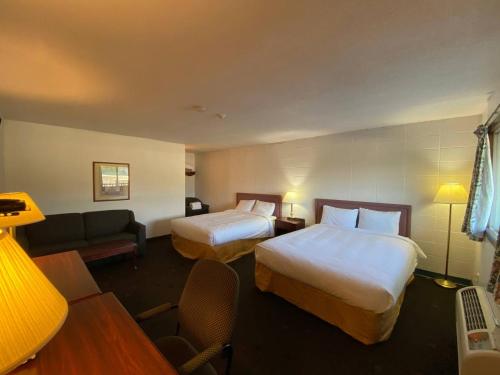 a hotel room with two beds and a couch at Bavarian Inn in Bruce Mines