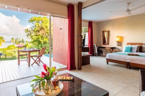 a hotel room with a bed and a balcony at Villa Physacap in Le François