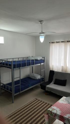 een kamer met 2 stapelbedden en een bank bij Apartamento Itanhanhem in Itanhaém