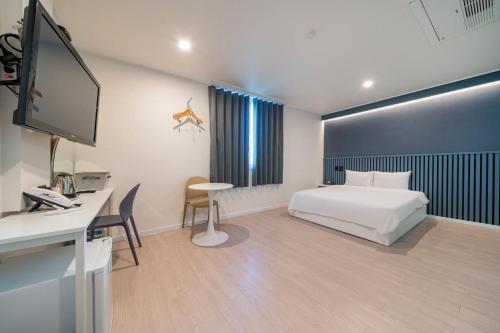 Habitación de hotel con cama y escritorio con ordenador en Hotel gongjicheon 2 en Chuncheon