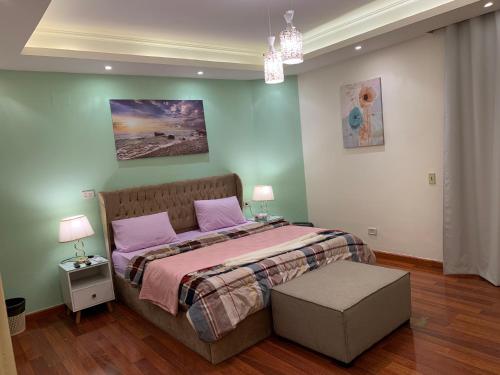 una camera da letto con un grande letto con cuscini rosa di Casa De Golf-أرض الجولف a Il Cairo