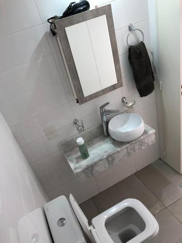 a bathroom with a toilet and a sink and a mirror at Palermo Apartamento Buenos Aires in Buenos Aires