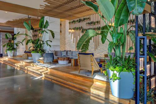 a lobby with a lot of plants and chairs at Marriott Virginia Beach Oceanfront Resort in Virginia Beach