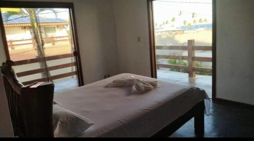 um quarto com uma cama e vista para a praia em Santorini Hospedaria em Ilhéus