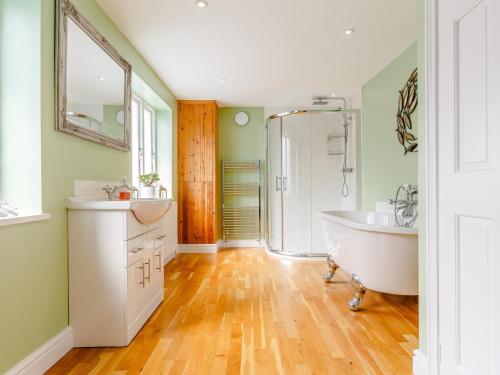 a bathroom with a tub and a sink and a shower at 4 Bed in Brixham 77366 in Brixham