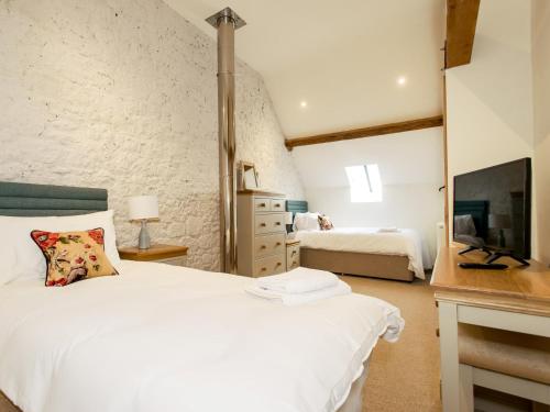 a bedroom with a white bed and a television at 3 Bed in Melbury Abbas 48804 in Melbury Abbas