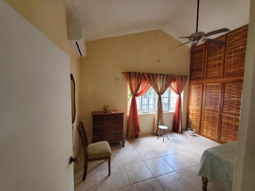 a bedroom with a bed and a dresser and a window at Yaad Away From Yaad in Manchioneal