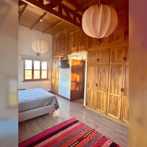 a bedroom with a bed and a refrigerator at Colibrí Tempo in Esquel