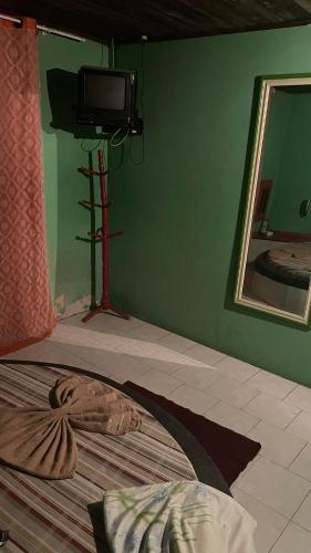 um quarto com uma televisão e uma cama com um espelho em Motel Casarão em Osório