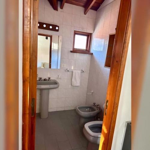 a bathroom with a toilet and a sink and a mirror at Colibrí Tempo in Esquel
