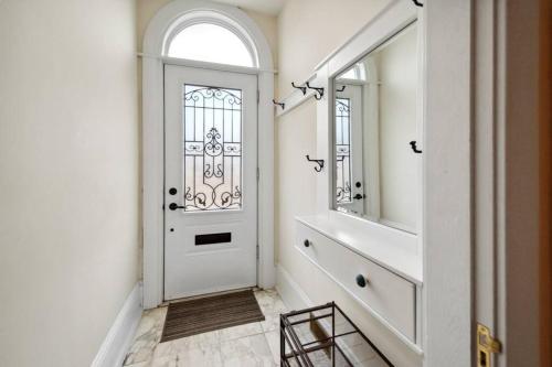 um corredor com uma porta branca e um espelho em Spacious & Cozy Home in Highfield St Moncton em Moncton