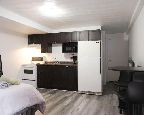 a kitchen with a white refrigerator and a table at Cozy studio apartment - 240 in Montréal