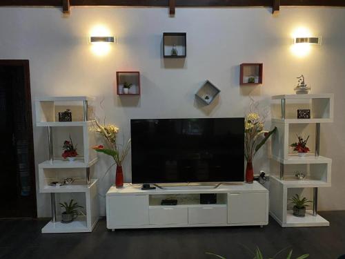 um grande centro de entretenimento branco com uma televisão de ecrã plano em MOOREA - Villa Tiahura em Hauru