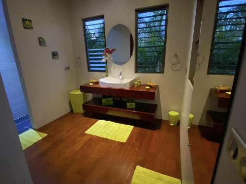 a bathroom with a sink and a mirror at MOOREA - Villa Tiahura in Hauru