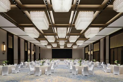 ein großer Bankettsaal mit weißen Tischen und Stühlen in der Unterkunft JW Marriott Hotel Xi'an Southwest in Xi'an