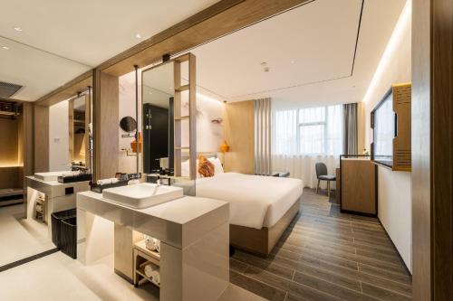 une chambre d'hôtel avec un lit et un lavabo dans l'établissement Paco Hotel Botanical Garden Metro Guangzhou-Free Shuttle Bus For Canton Fair, à Canton