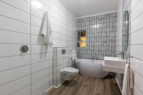 a white bathroom with a toilet and a sink at Ocean Villa in Durban
