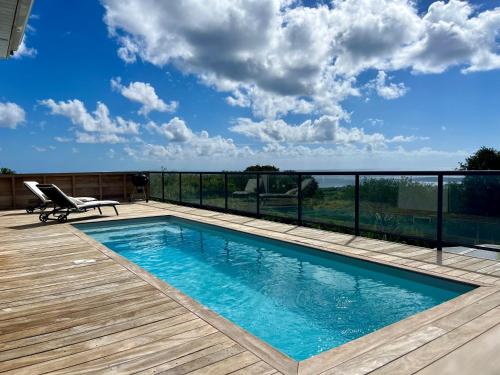 a swimming pool on the deck of a house at La villa O'rizon in Le Diamant