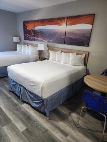a hotel room with two beds and a table at Days Inn & Suites by Wyndham Tucson/Marana in Tucson