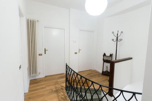 a white room with a staircase and a door at Appartamento con Vista nel Centro Storico di Gubbio in Gubbio