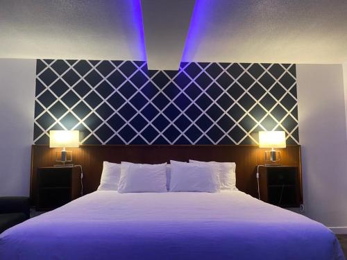 a bedroom with a large bed with two lights on it at Bavarian Inn in Bruce Mines