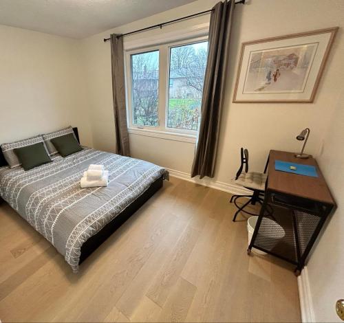a bedroom with a bed and a desk and a window at Premium home with Garden view, private parking in Toronto