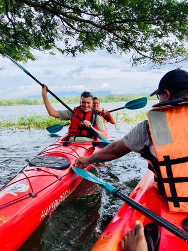 3 persone in un kayak rosso sull'acqua di lotuscool hotel a Kurunegala