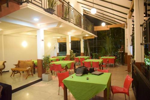 un ristorante con tavoli verdi e sedie rosse di lotuscool hotel a Kurunegala