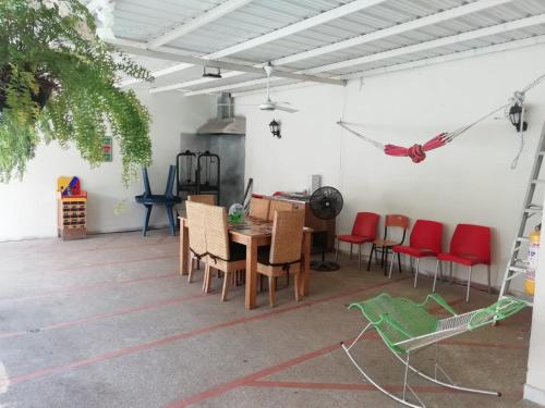 comedor con sillas rojas y mesa en Casa Quinta Villa Rosita, en Carmen de Apicalá