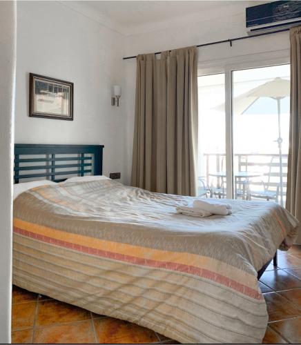 a large bed in a bedroom with a large window at Mirador Golf Cabo Negro in Cabo Negro