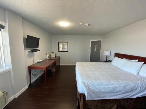 a bedroom with a bed and a desk and a television at Bavarian Inn in Bruce Mines
