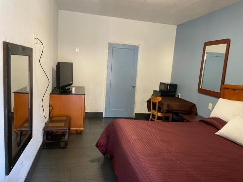a hotel room with a bed and a television at Laurel Inn in Oakland