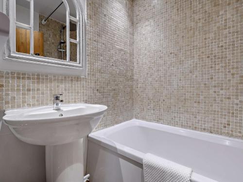 2 Bed in Slimbridge 90719 في كامبريدج: حمام مع حوض وحوض ومرآة