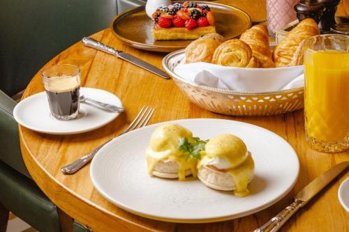 a table with plates of pastries and a basket of bread at Sheraton Grand London Park Lane in London