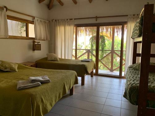 曼科拉的住宿－Terraza Salvatore, Casa en Las Pocitas de Máncora，酒店客房设有两张床和一个阳台。
